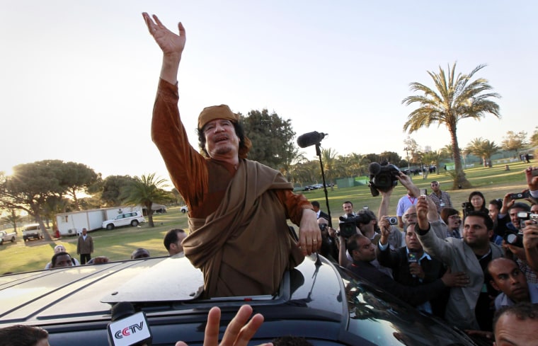 Image: Libyan leader Muammar Gaddafi waves from a car in the compound of Bab Al Azizia in Tripoli