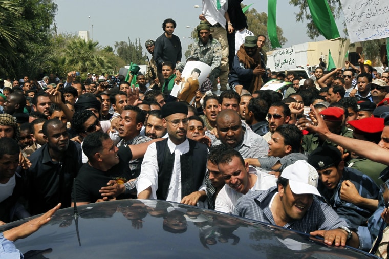 Image: Libyan leader Muammar Gaddafi's son Saif al-Islam Gaddafi leaves after the funeral of his brother Saif Al-Arab Gaddafi, who was killed after air strikes by coalition forces last Saturday, at the El Hani cemetery in Tripoli