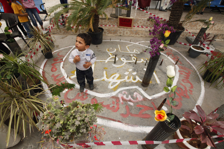 Image: A boy stands at the site where his father was killed during a fierce battle against forces loyal to Muammar Gaddafi in Tripoli street in central Misrata