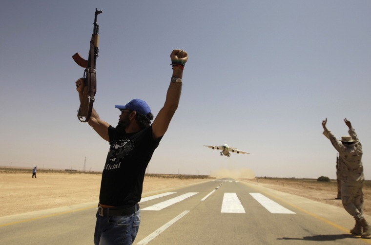 Rebels wave as an Air Libya aircraft takes off from Rhebat air strip on July 12, 2011. Ali Tarhouni, the oil and finance minister in the council opposing Gadhafi, opened the airfield linking the rebel capital Benghazi with a remote Western Mountain stronghold south of Tripoli.