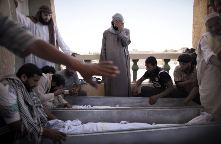 During a funeral in Zintan on July 14, 2011, Libyan mourners gather around the coffins of eight rebels killed during clashes with loyalist troops in the flashpoint hilltop town of Gualish.
