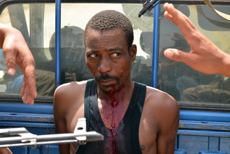 A fighter loyal to Gadhafi is captured by rebel forces on August 6, 2011, as they advance on the town of Bir Ghanam, 50 miles south of the Libyan capital Tripoli.