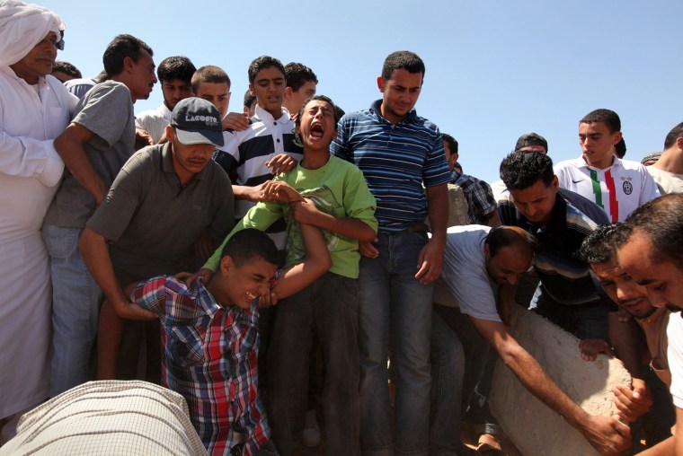 Image: Libyans mourn as they bury a rebel killed in the industrial area of Brega by forces loyal to Gaddafi, in Benghazi