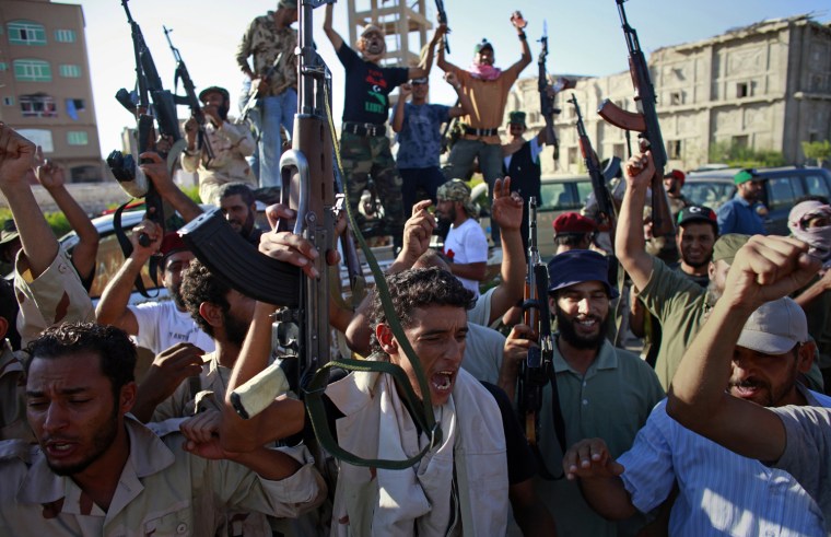 Image: Libyan rebel fighters celebrate after taking control of the coastal town of Sabratha