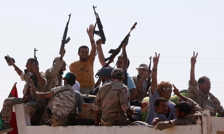 Image: Libyan rebel fighters raise their arms in celebration