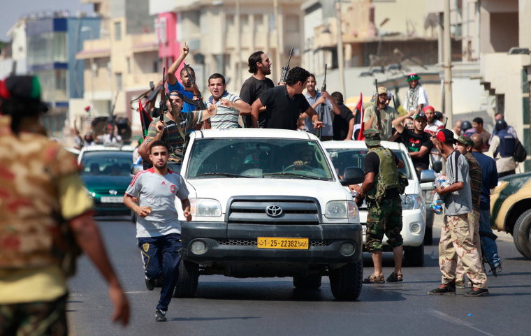 Libyan rebel fighters celebrate as they drive through Tripoli's Qarqarsh district on August 22, 2011.