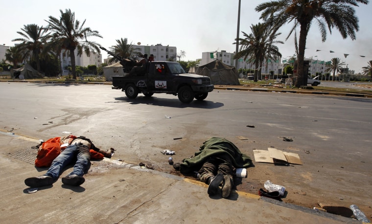 Image: Dead bodies lie just outside the south gate of Bab al Aziziya compound in Tripoli