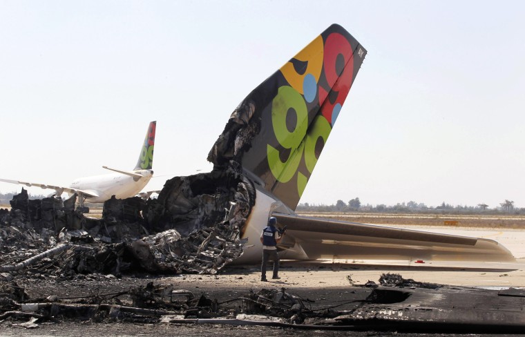 Image: A cameraman works near a destroyed Afriqiyah Airways aircraft at the Tripoli Airport