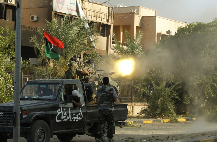 Image: A Libyan rebel fighter fires his heavy machine gun during a fight for the final push to flush out Muammar Gaddafi's forces in Abu Salim district in Tripoli