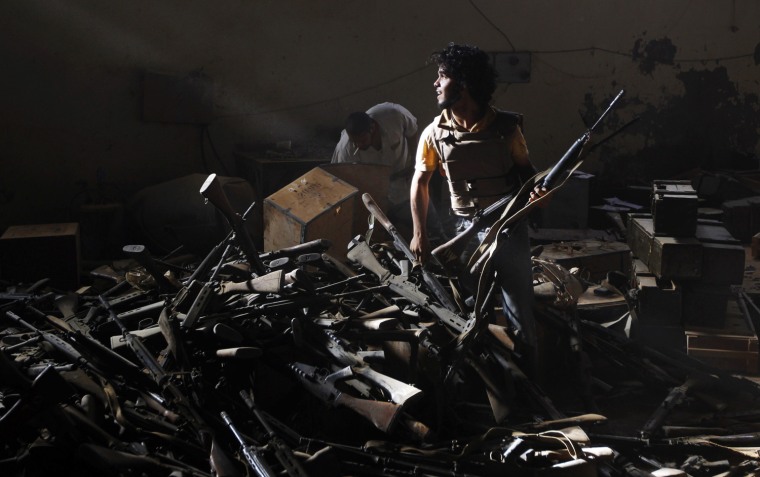 An anti-Gadhafi fighter salvages weapons at Gadhafi weapons and ammunition compound in a village near Sirte, one of the dictator’s last remaining strongholds, on Sept. 19, 2011.