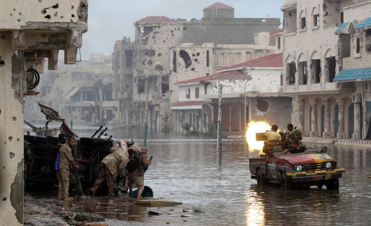 Libyan rebel fighters fire at pro-Gadhafi forces during the battle to liberate the city of Sirte on Oct. 13, 2011.
