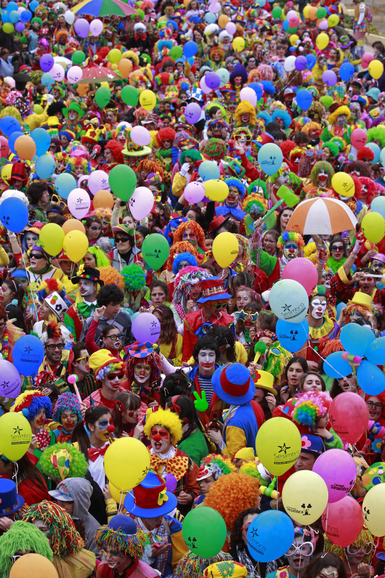 Image: Revellers dressed as clowns participate in a carnival parade in Sesimbra village