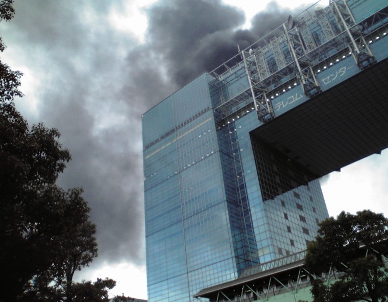Image: A building burns after an earthquake in the Odaiba district of Tokyo