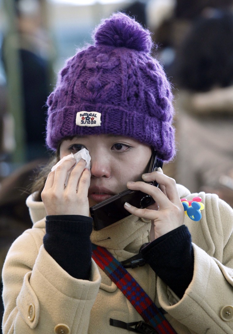 Image: A Japanese traveler wipes tears as she t
