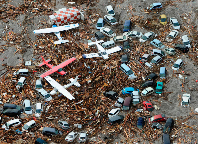 Image: Cars and airplanes swept by a tsunami are pictured among debris at Sendai Airport, northeastern Japan