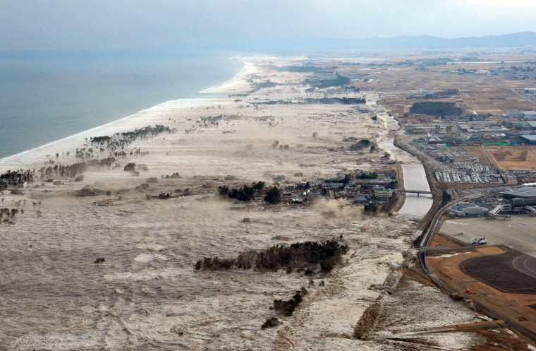 Image: A massive tsunami hits the coastal areas of Iwanuma, Miyagi Prefecture, northeastern Japan