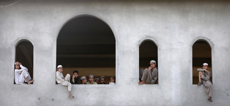 Image: Students look towards the compound where al-Qaeda leader Osama bin Laden was killed from a nearby madrasa in Abbottabad