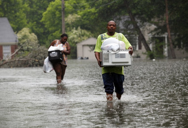 Image: Jonathan White and Leandra Felton wade through slowly rising floodwaters with items from their home in Memphis