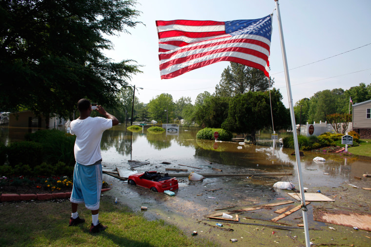Image: A man takes a picture of a flooded mobile home park as floodwaters slowly rise in Memphis
