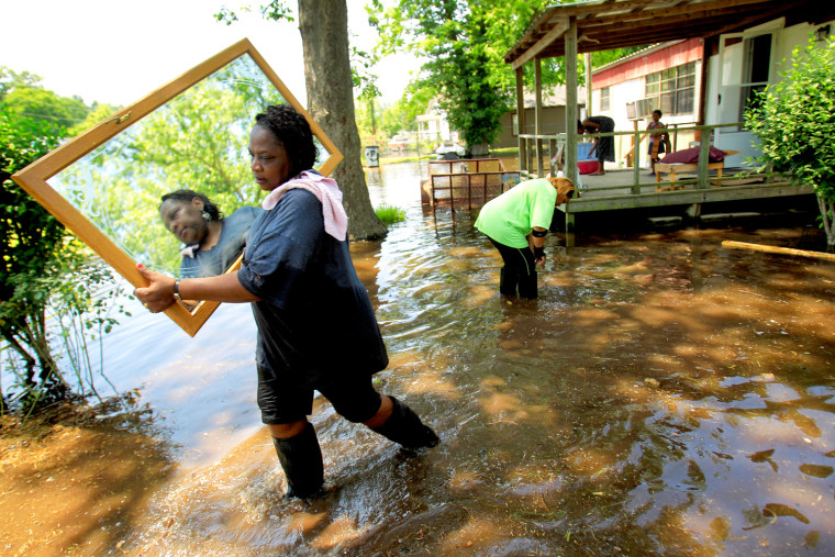 Image: Melvina Jones carries a mirror through flood waters in Vicksburg