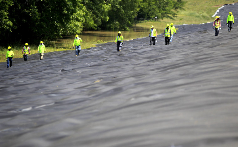Image: Workers look for minor imperfections to correct before pining down high density polyethylene (HDPE) on the backside of the Yazoo Backwater Levee in Vicksburg, Mississippi.