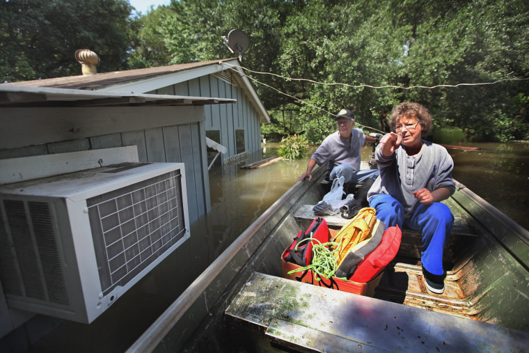 Image: Guy Creekmore (L) and his wife Diane check out their flooded home