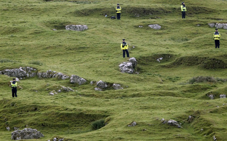 Image: Irish police officers stand guard as Britain's Queen Elizabeth and Prince Philip arrive at St Patrick's Rock in Cashel