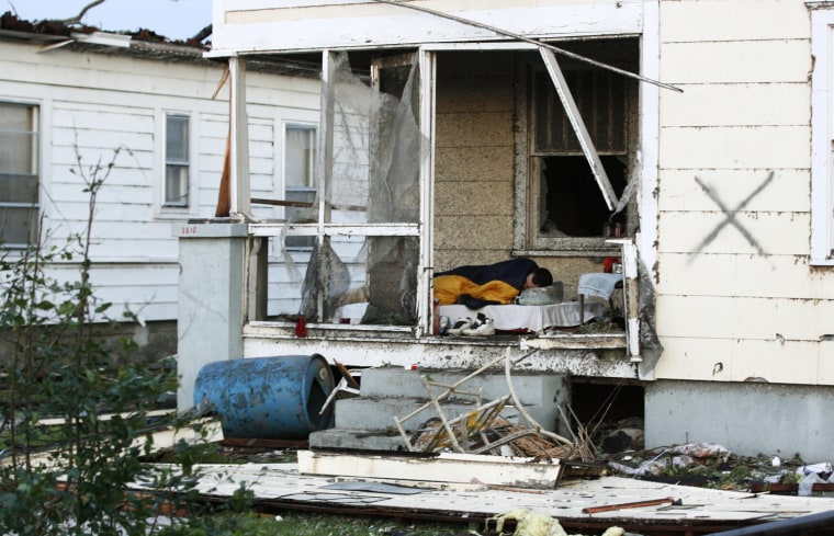 Image: A man sleeps on his front porch the morning after a tornado ripped off the roof of his home when it hit Joplin
