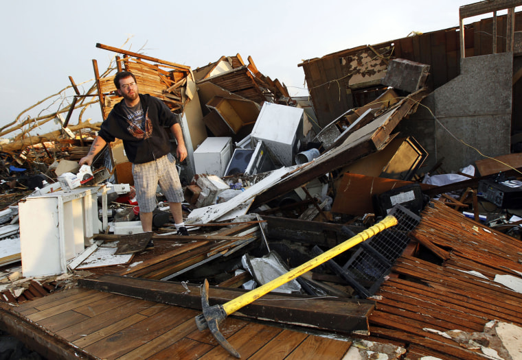 Image: A man sorts through the debris looking for personal belongings after his home was destroyed when a tornado hit Joplin