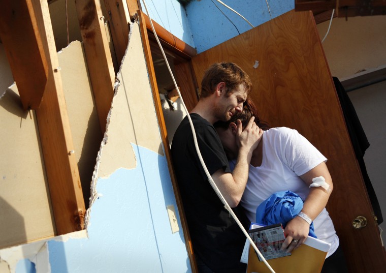 Image: Kyle and Alicia Gordon cry and embrace in their son's room after losing their home to a devastating tornado that hit Joplin