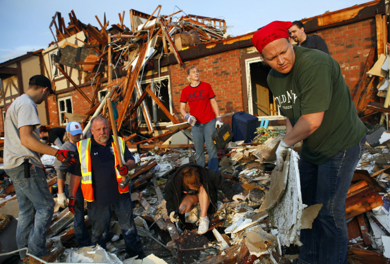 Image: Volunteers look for survivors in the rubble of a home after a devastating tornado hit Joplin