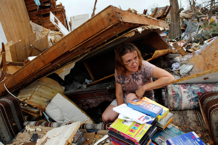 Image: Jeannie Owens searches through a family member's destroyed home after a devastating tornado hit Joplin, Missouri