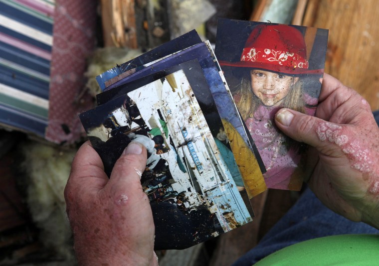 Image: Jerry Parker looks through pictures recovered from his destroyed home after a devastating tornado hit Joplin, Missouri