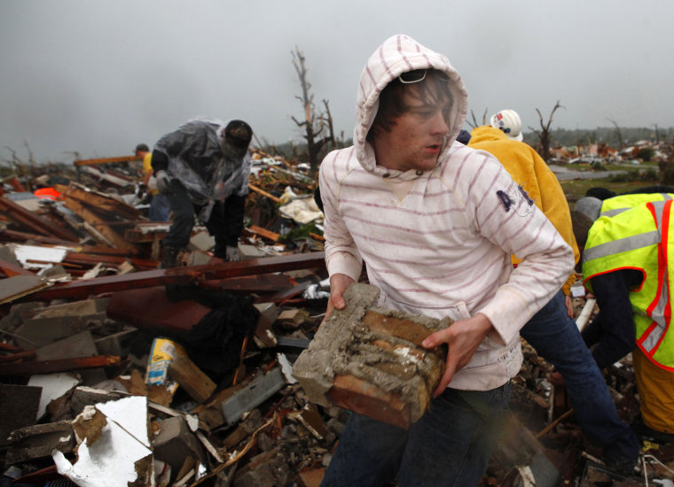 Image: Volunteers clear rubble as they look for survivors after a devastating tornado hit Joplin