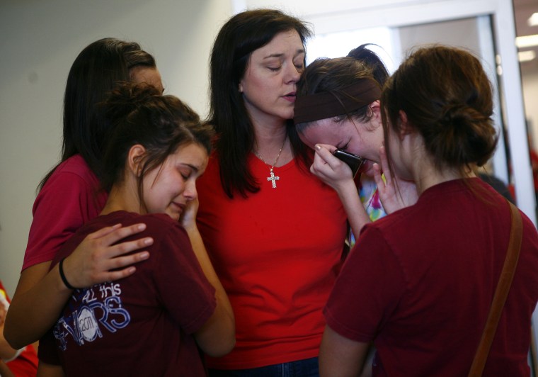 Image: Tracey Presslor comforts friends and classmates of her nephew Will Norton at a news conference in Joplin, Missouri