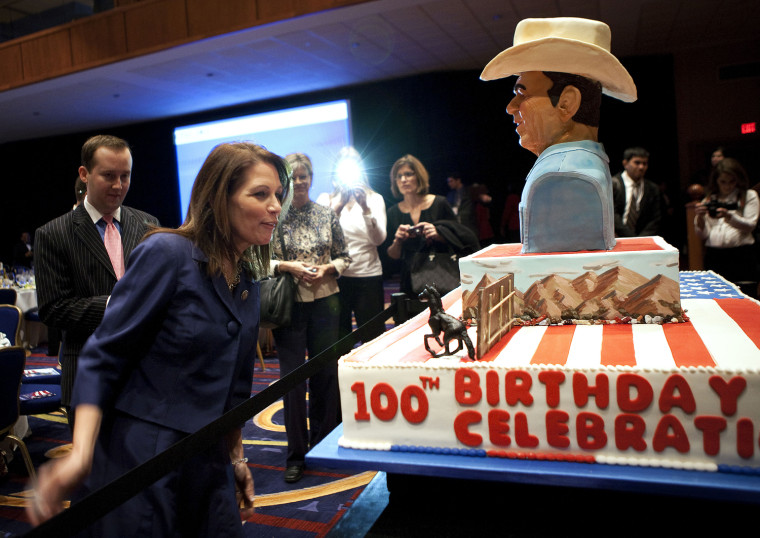 Image: Representative Bachmann looks at a cake commemorating the 100th birthday of former president Reagan in Washington