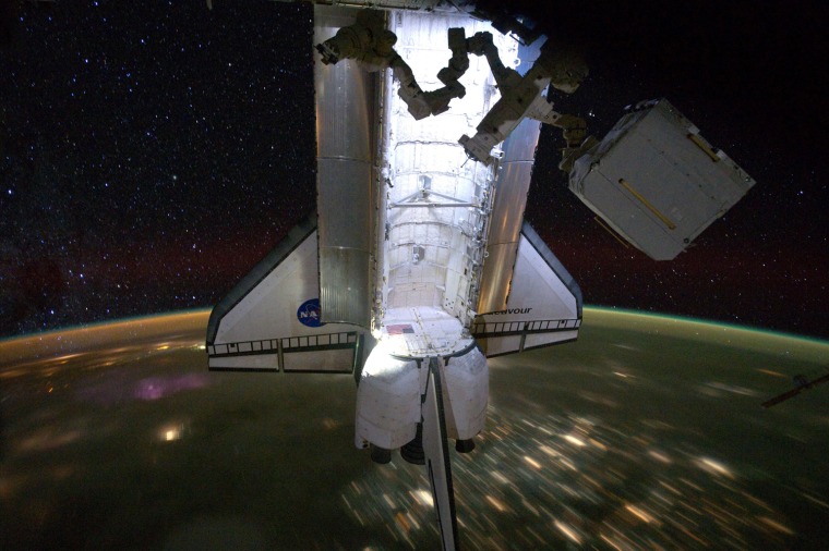 Image: Backdropped by a night time view of the Earth and the starry sky, the Space Shuttle Endeavour is seen docked to the International Space Station