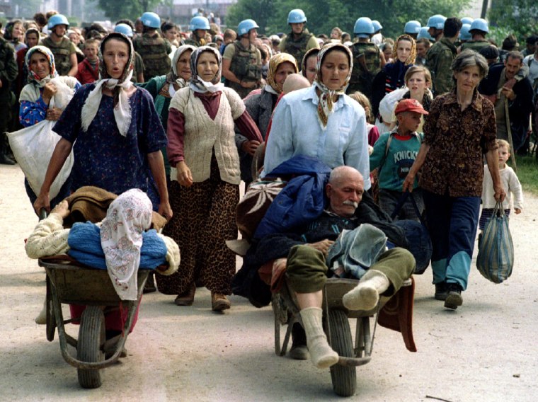 Image: Group of Bosnian Moslems, refugees from Srebrenica, walk to be transported near Potocari