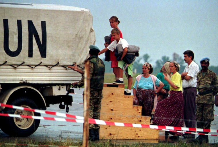 Bosnian refugees from Srebrenica board a UN truck to be taken to the tents at the refugee camp in th..