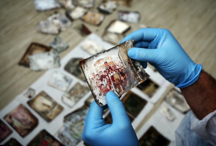 Forensic expert holds a photograph found with remains of a victim of 1995 Srebrenica ...