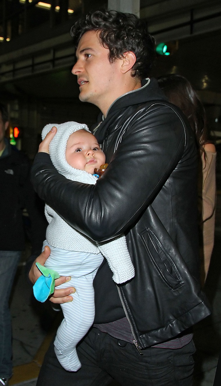 Orlando Bloom carries baby Flynn as they arrive in JFK Airport with Miranda Kerr in NYC