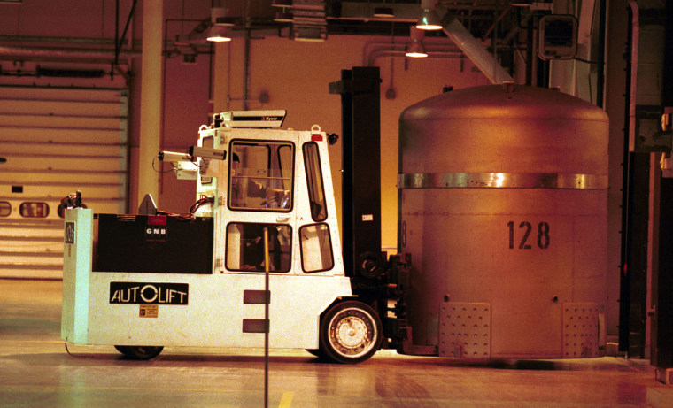 A forklift is used to transfer a TRUPACT0-II from the trailer