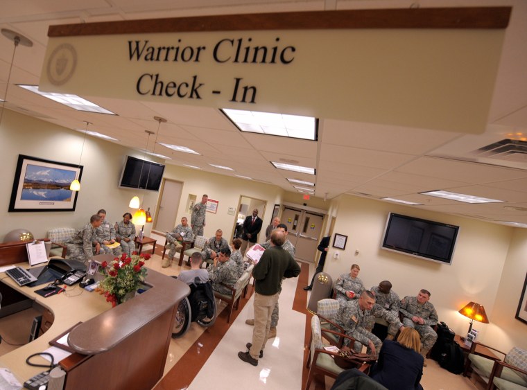 US Army medical staff and patients sit i