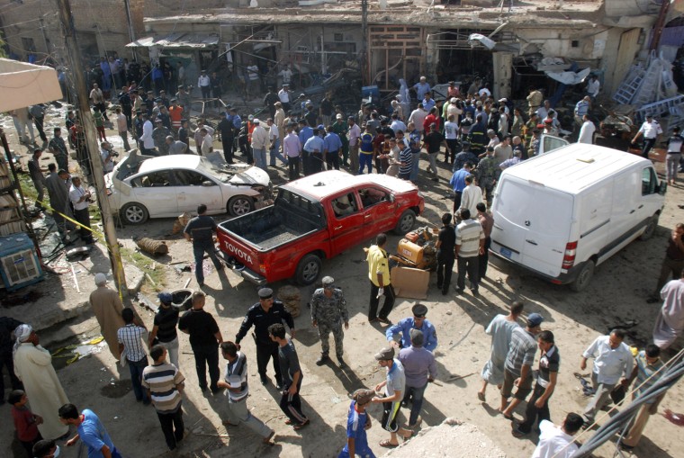 Image: Residents gather at the site of bomb attacks in Kut