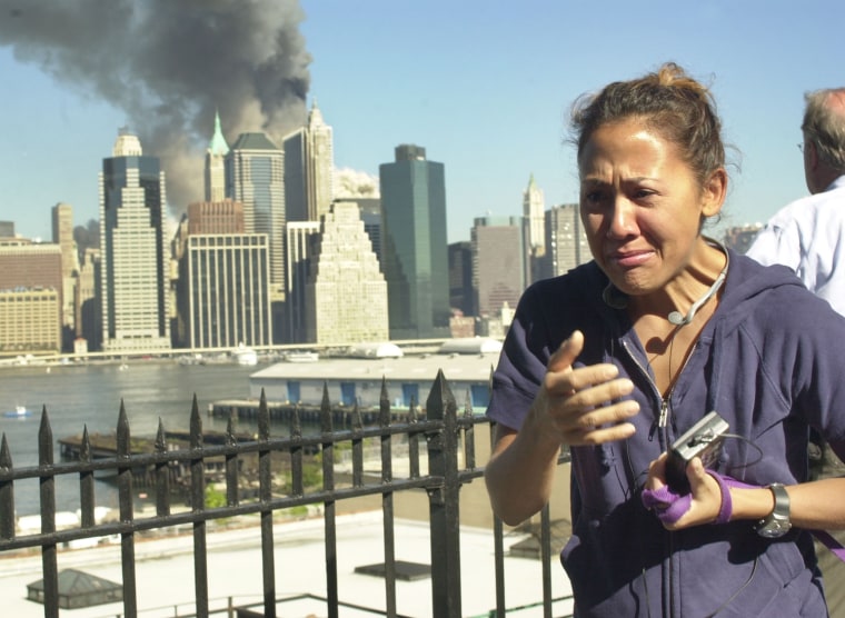 A woman reacts to a third explosion, possibly the collapse of the World Trade Center towers, while observing from the Brooklyn Promenade, which provides a view of the Manhattan skyline, Tuesday, Sept. 11, 2001, in New York. (AP Photo/Kathy Willens)