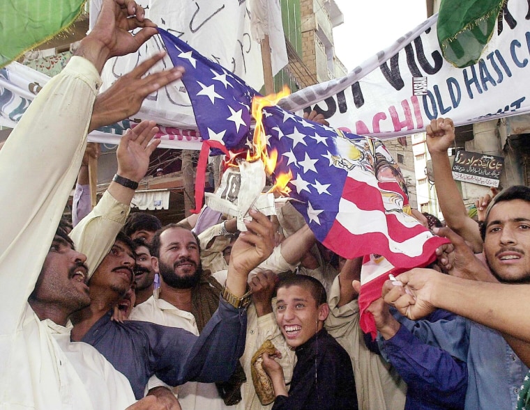 Activists of a right-wing group burn the US flag in southern Karachi on 17 September 2001, to show their anger over the imminent attacks of the US on Afghanistan by using Pakistan's land. Local police arrested at least 24 activists as the holding of such demonstrations has been banned. AFP PHOTO/Aamir QURESHI