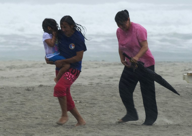 Image: Beach goers get caught in a squall as feeder bands from Hurricane Irene begin to pound Atlantic Beach