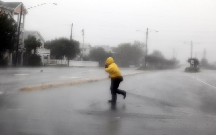 Image: A pedestrian crosses an open area as Hurricane Irene passes through Wrightsville Beach, North Carolina