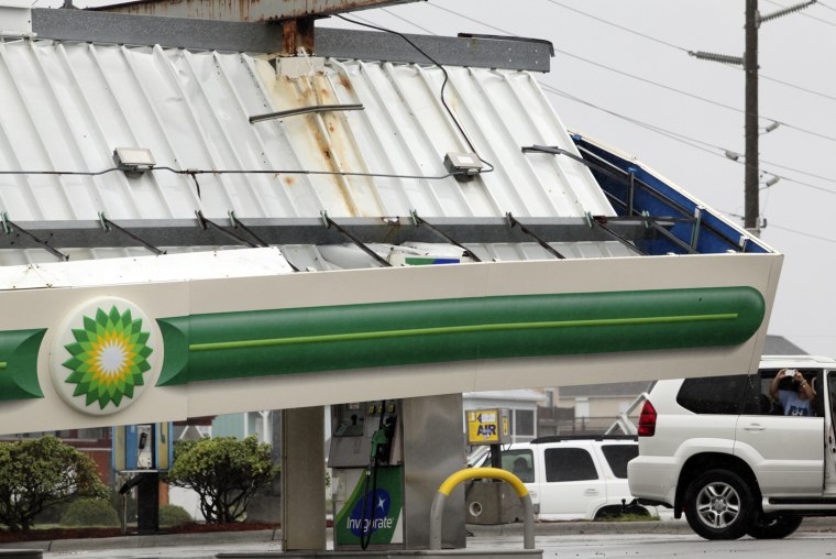 Image: An onlooker takes a photo of a fallen gas canopy hit by Hurricane Irene, at the Atlantic Food Mart in Surf City