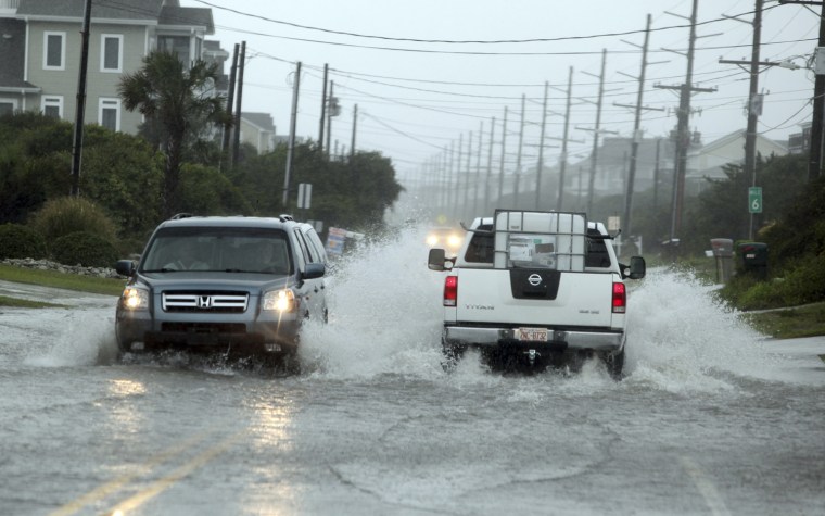 Image: Vehicles go through a flooded area on N. New River Drive August 27, 2011 during Hurricane Irene in Surf City, N.C.